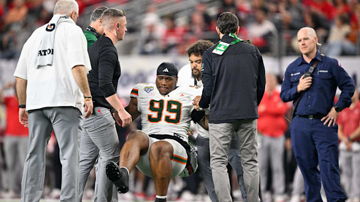 Dec 31, 2025; Arlington, TX, USA; Miami Hurricanes defensive line Ahmad Moten Sr. (99) is helped off the field during the third quarter against the Ohio State Buckeyes during the 2025 Cotton Bowl and quarterfinal game of the College Football Playoff at AT&T Stadium. Mandatory Credit: Jerome Miron-Imagn Images Dec 31, 2025; Arlington, TX, USA; Miami Hurricanes defensive line Ahmad Moten Sr. (99) is helped off the field during the third quarter against the Ohio State Buckeyes during the 2025 Cotton Bowl and quarterfinal game of the College Football Playoff at AT&T Stadium. Mandatory Credit: Jerome Miron-Imagn Images