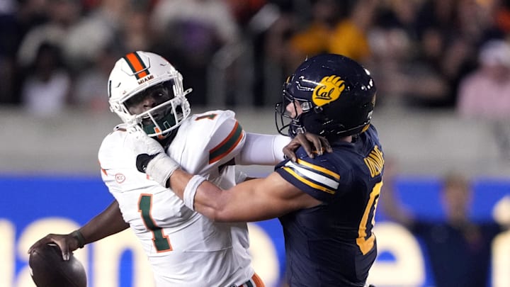 Oct 5, 2024; Berkeley, California, USA; California Golden Bears linebacker Cade Uluave (right) grabs Miami Hurricanes quarterback Cam Ward (1) during the third quarter at California Memorial Stadium. Mandatory Credit: Darren Yamashita-Imagn Images