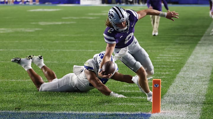 Sep 21, 2024; Provo, Utah, USA; Kansas State Wildcats quarterback Avery Johnson (2) reaches for a touchdown against Brigham Young Cougars defensive end Logan Lutui (59) during the third quarter at LaVell Edwards Stadium. Mandatory Credit: Rob Gray-Imagn Images