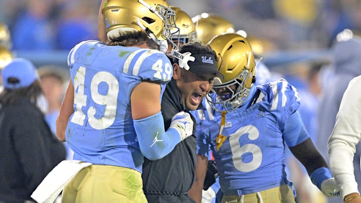 Nov 8, 2024; Pasadena, California, USA;   UCLA Bruins defensive coordinator Ikaika Malloe, center, celebrates with linebacker Carson Schwesinger (49) defensive back Jaylin Davies (6) after an interception in the second half against the Iowa Hawkeyes at the Rose Bowl. Mandatory Credit: Jayne Kamin-Oncea-Imagn Images