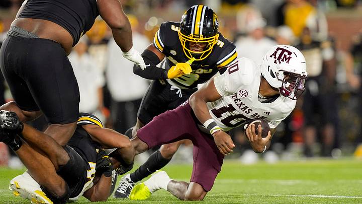 Nov 8, 2025; Columbia, Missouri, USA; Texas A&M Aggies quarterback Marcel Reed (10) dives forward against Missouri Tigers linebacker Josiah Trotter (40) and safety Mose Phillips III (3) and defensive tackle Marquis Gracial (33) during the second half at Faurot Field at Memorial Stadium. Mandatory Credit: Jay Biggerstaff-Imagn Images