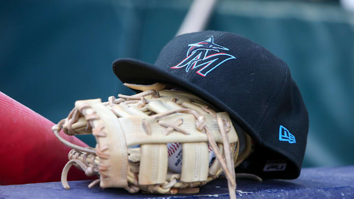 Apr 24, 2024; Atlanta, Georgia, USA; A detailed view of a Miami Marlins hat and glove in the dugout before a game against the Atlanta Braves at Truist Park. 