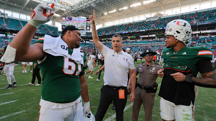 Nov 23, 2024; Miami Gardens, Florida, USA; Miami Hurricanes head coach Mario Cristobal celebrates with Miami Hurricanes offensive lineman Francis Mauigoa (61) and tight end Elijah Arroyo (8) after the game against the Wake Forest Demon Deacons at Hard Rock Stadium. Mandatory Credit: Sam Navarro-Imagn Images Nov 23, 2024; Miami Gardens, Florida, USA; Miami Hurricanes head coach Mario Cristobal celebrates with Miami Hurricanes offensive lineman Francis Mauigoa (61) and tight end Elijah Arroyo (8) after the game against the Wake Forest Demon Deacons at Hard Rock Stadium. Mandatory Credit: Sam Navarro-Imagn Images