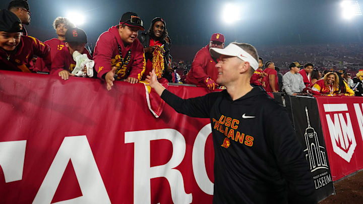 Nov 29, 2025; Los Angeles, California, USA; Southern California Trojans head coach Lincoln Riley celebrates with fans after the game against the UCLA Bruins at United Airlines Field at Los Angeles Memorial Coliseum. Mandatory Credit: Kirby Lee-Imagn Images