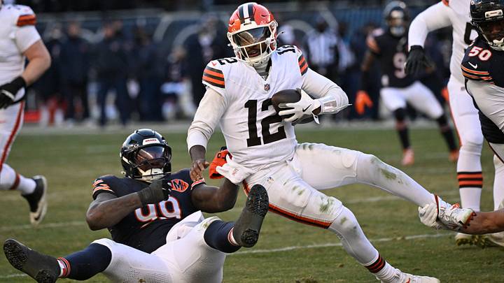 Shedeur Sanders pulls away ffrom Gervon Dexter but falls for a sack  last year at Soldier Field.