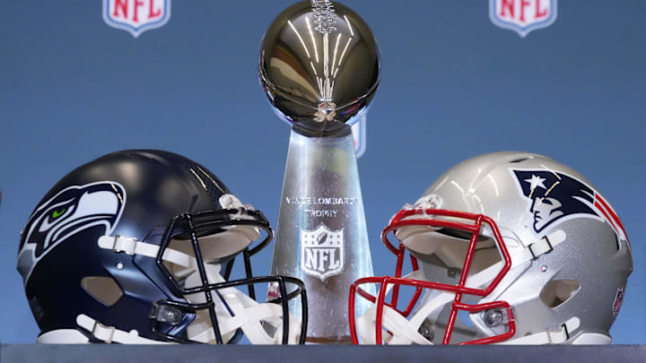 The Seattle Seahawks and New England Patriots helmets are displayed with the Vince Lombardi Trophy before a press conference.
