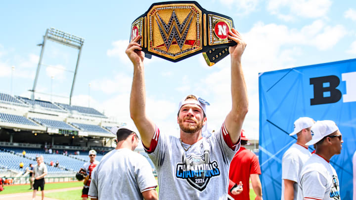 Kyle Perry lifts a golden championship belt. 