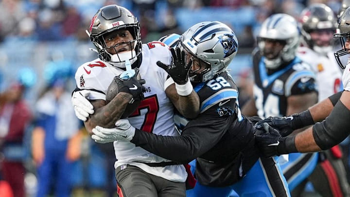 Dec 1, 2024; Charlotte, North Carolina, USA; Tampa Bay Buccaneers running back Bucky Irving (7) is tackled by Carolina Panthers linebacker DJ Johnson (52) during the first quarter at Bank of America Stadium. 