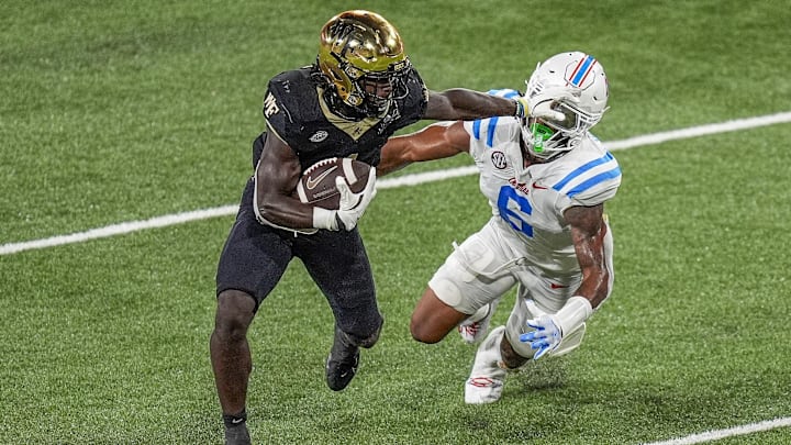 Sep 14, 2024; Winston-Salem, North Carolina, USA;  Wake Forest Demon Deacons running back Demond Claiborne (1) stiff arms Mississippi Rebels linebacker TJ Dottery (6) during the second half at Allegacy Federal Credit Union Stadium. Mandatory Credit: Jim Dedmon-Imagn Images
