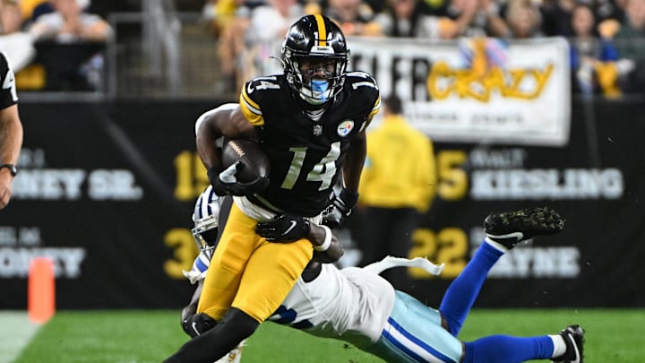 Oct 6, 2024; Pittsburgh, Pennsylvania, USA; Pittsburgh Steelers wide receiver George Pickens (14) breaks a tackle by Dallas Cowboys cornerback Jourdan Lewis (2) during the first quarter at Acrisure Stadium. Mandatory Credit: Barry Reeger-Imagn Images





