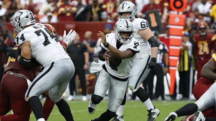 Sep 21, 2025; Landover, Maryland, USA; Las Vegas Raiders quarterback Geno Smith (7) scrambles from Washington Commanders defensive tackle Jer'Zhan Newton (95) during the third quarter at Northwest Stadium. Mandatory Credit: Geoff Burke-Imagn Images