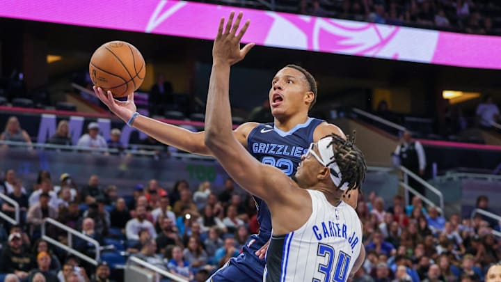 Oct 11, 2022; Orlando, Florida, USA; Memphis Grizzlies guard Desmond Bane (22) goes to the basket against Orlando Magic center Wendell Carter Jr. (34) during the second half at Amway Center. Mandatory Credit: Mike Watters-Imagn Images