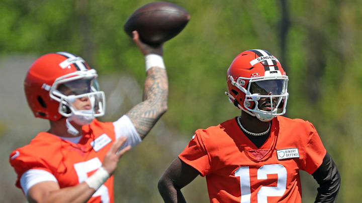 Cleveland Browns quarterback Shedeur Sanders (12) watches as quarterback Dillon Gabriel (5) throws during NFL rookie minicamp at the Cleveland Browns training facility on Friday, May 9, 2025, in Berea, Ohio.