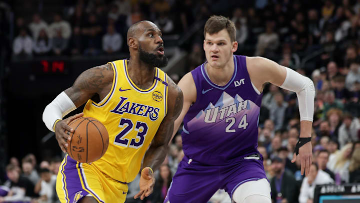 Feb 12, 2025; Salt Lake City, Utah, USA;  Los Angeles Lakers forward LeBron James (23) dribbles past Utah Jazz center Walker Kessler (24) during the first quarter at Delta Center. Mandatory Credit: Chris Nicoll-Imagn Images