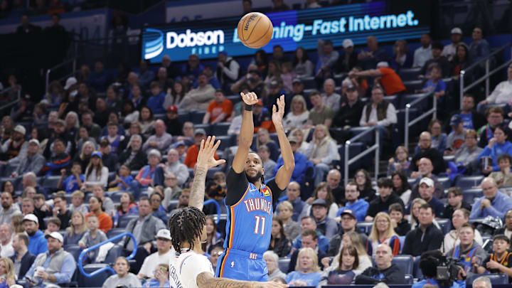 Mar 19, 2025; Oklahoma City, Oklahoma, USA; Oklahoma City Thunder guard Isaiah Joe (11) shoots a three point basket over Philadelphia 76ers guard Jalen Hood-Schifino (17) during the second half at Paycom Center. Mandatory Credit: Alonzo Adams-Imagn Images