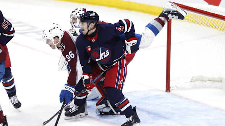 Nov 7, 2024; Winnipeg, Manitoba, CAN; Colorado Avalanche right wing Mikko Rantanen (96) and Winnipeg Jets defenseman Neal Pionk (4) collide in front of goaltender Connor Hellebuyck (37) in the third period at Canada Life Centre. Mandatory Credit: James Carey Lauder-Imagn Images