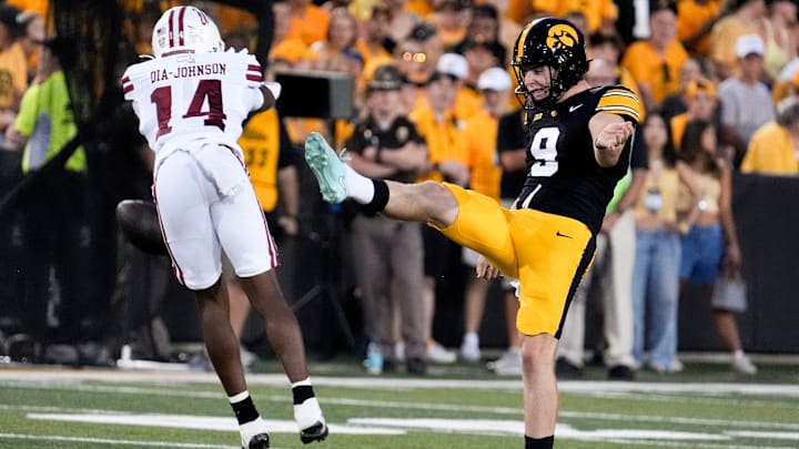 Massachusetts wide receiver Kezion Dia-Johnson (14) blocks a punt by Iowa's Rhys Dakin on Sept. 13, 2025 at Kinnick Stadium in Iowa City.