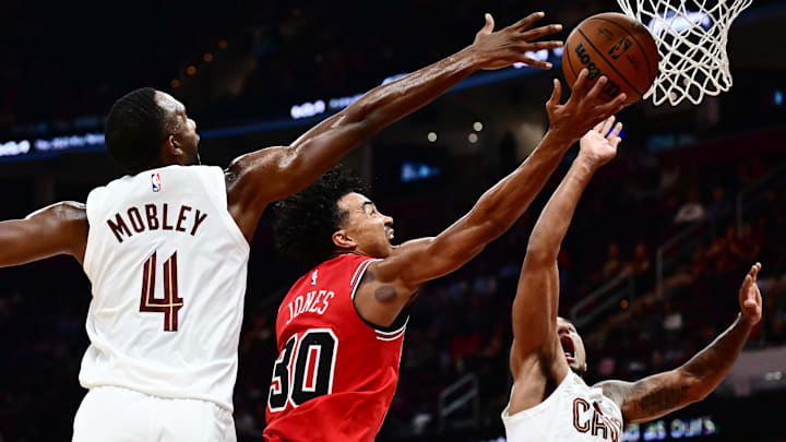 Oct 7, 2025; Cleveland, Ohio, USA; Chicago Bulls guard Tre Jones (30) drives to the basket between Cleveland Cavaliers forward Evan Mobley (4) and forward Jaylon Tyson (20) during the second half at Rocket Arena. Mandatory Credit: Ken Blaze-Imagn Images