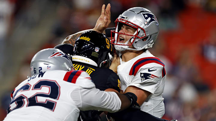 Aug 25, 2024; Landover, Maryland, USA; New England Patriots quarterback Drake Maye (10) is hit by Washington Commanders defensive tackle John Ridgeway III (91) after throwing a pass during the second quarter during a preseason game at Commanders Field. Mandatory Credit: Peter Casey-USA TODAY Sports