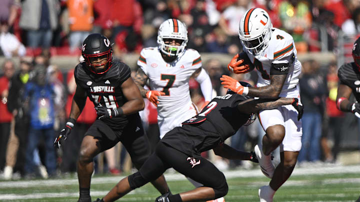 Oct 19, 2024; Louisville, Kentucky, USA; Miami Hurricanes running back Mark Fletcher Jr. (4) runs the ball against Louisville Cardinals defensive back Tamarion McDonald (12) during the first half at L&N Federal Credit Union Stadium. Miami defeated Louisville 52-45. Mandatory Credit: Jamie Rhodes-Imagn Images Oct 19, 2024; Louisville, Kentucky, USA; Miami Hurricanes running back Mark Fletcher Jr. (4) runs the ball against Louisville Cardinals defensive back Tamarion McDonald (12) during the first half at L&N Federal Credit Union Stadium. Miami defeated Louisville 52-45. Mandatory Credit: Jamie Rhodes-Imagn Images