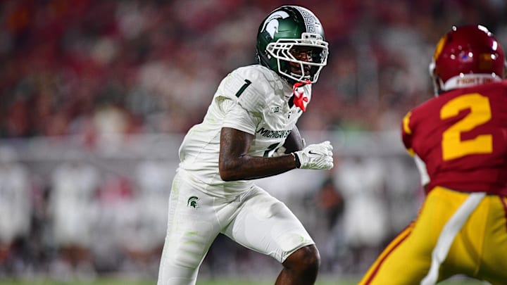 Sep 20, 2025; Los Angeles, California, USA; Michigan State Spartans wide receiver Omari Kelly (1) runs the ball against Southern California Trojans cornerback DJ Harvey (2) during the first half at the Los Angeles Memorial Coliseum. Mandatory Credit: Gary A. Vasquez-Imagn Images
