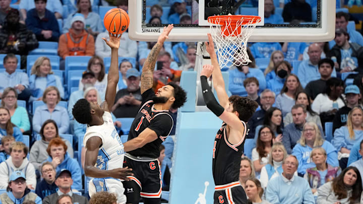 Dec 29, 2024; Chapel Hill, North Carolina, USA; North Carolina Tar Heels guard Drake Powell (9) shoots as Campbell Fighting Camels guard Tasos Cook (1) and guard Caleb Zurliene (14) defend in the first half at Dean E. Smith Center. Mandatory Credit: Bob Donnan-Imagn Images