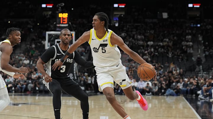 Nov 9, 2024; San Antonio, Texas, USA;  Utah Jazz forward Cody Williams (5) dribbles past San Antonio Spurs guard Chris Paul (3) in the first half at Frost Bank Center. Mandatory Credit: Daniel Dunn-Imagn Images