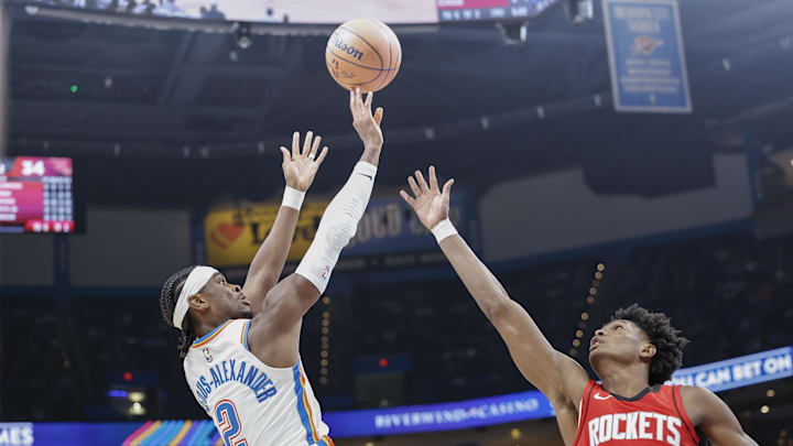 Oct 9, 2024; Oklahoma City, Oklahoma, USA; Oklahoma City Thunder guard Shai Gilgeous-Alexander (2) shoots over Houston Rockets forward Amen Thompson (1) during the second quarter at Paycom Center. Mandatory Credit: Alonzo Adams-Imagn Images