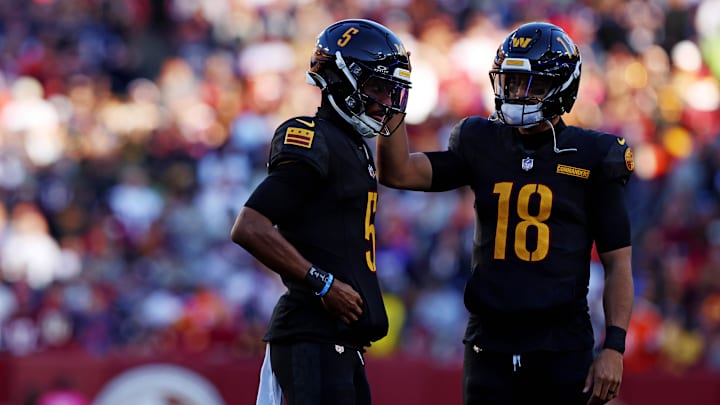 Oct 27, 2024; Landover, Maryland, USA; Washington Commanders quarterback Jayden Daniels (5) and quarterback Marcus Mariota (18) talk to each other during the first half against the Chicago Bears at Commanders Field.