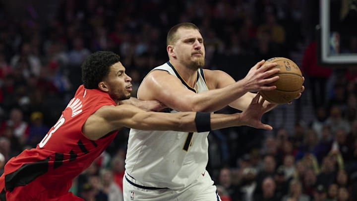 Oct 31, 2025; Portland, Oregon, USA; Portland Trail Blazers forward Toumani Camara (33) attempts to steal the basketball during the second half against Denver Nuggets center Nikola Jokic (15) at Moda Center. Mandatory Credit: Troy Wayrynen-Imagn Images