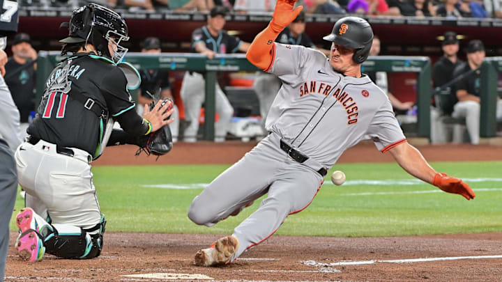 Sep 23, 2024; Phoenix, Arizona, USA;  San Francisco Giants third baseman Matt Chapman (26) slides home with an inside the park home run as Diamondbacks catcher Jose Herrera (11) defends in the third inning at Chase Field. Mandatory Credit: Matt Kartozian-Imagn Images