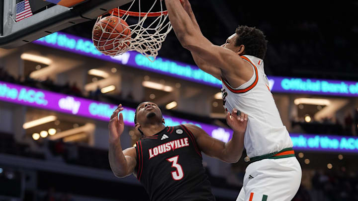 Mar 12, 2026; Charlotte, NC, USA; Miami (FL) Hurricanes forward Malik Reneau (5) makes a slam dunk against Louisville Cardinals guard Ryan Conwell (3) during the first half at Spectrum Center. Mandatory Credit: Jim Dedmon-Imagn Images