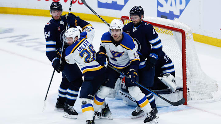 Apr 30, 2025; Winnipeg, Manitoba, CAN; St. Louis Blues forward Nathan Walker (26) and St. Louis Blues forward Alexey Toropchenko (13) jostle for position with Winnipeg Jets defenseman Dylan Samberg (54) and Winnipeg Jets defenseman Neal Pionk (4) during the third period in game five of the first round of the 2025 Stanley Cup Playoffs at Canada Life Centre. Mandatory Credit: Terrence Lee-Imagn Images