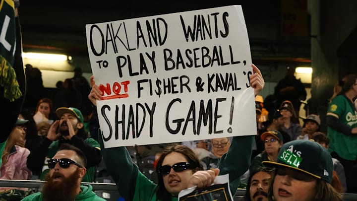 Apr 28, 2023; Oakland, California, USA; An Oakland Athletics fan holds a sign in reference to owner