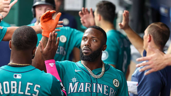 Sep 16, 2025; Kansas City, Missouri, USA; Seattle Mariners left fielder Randy Arozarena (56) is congratulated by teammates after scoring a run in the first inning against the Kansas City Royals at Kauffman Stadium. Mandatory Credit: Scott Sewell-Imagn Images
