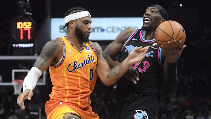 Mar 6, 2026; Charlotte, North Carolina, USA;  Miami Heat center Bam Adebayo (13) drives in defended by Charlotte Hornets forward Miles Bridges (0) during the first half at the Spectrum Center. Mandatory Credit: Sam Sharpe-Imagn Images.