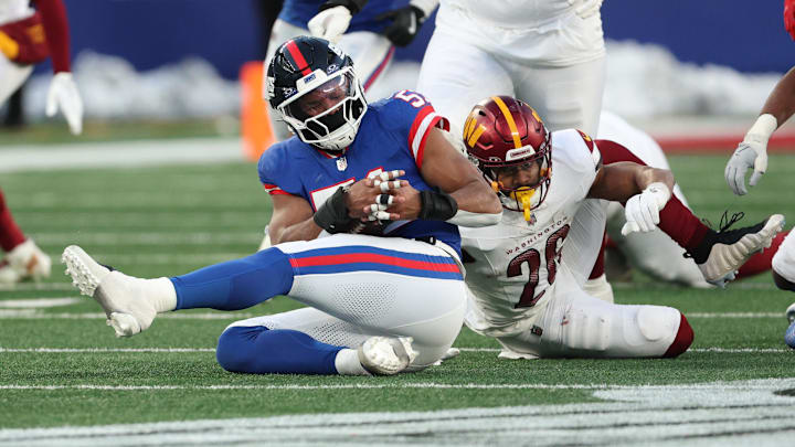 Dec 14, 2025; East Rutherford, New Jersey, USA;  Washington Commanders running back Jeremy McNichols (26) fumbles the ball being tackled by New York Giants linebacker Abdul Carter (51) during the fourth quarter at MetLife Stadium. 