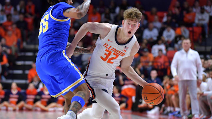 Feb 11, 2025; Champaign, Illinois, USA;  Illinois Fighting Illini guard Kasparas Jakucionis (32) drives the ball against UCLA Bruins guard Skyy Clark (55) during the first half at State Farm Center. Mandatory Credit: Ron Johnson-Imagn Images