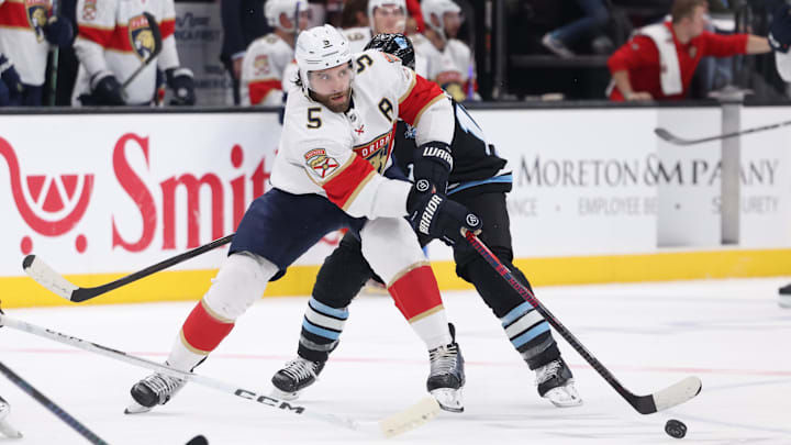 Jan 8, 2025; Salt Lake City, Utah, USA; Florida Panthers defenseman Aaron Ekblad (5) passes the puck against the Utah Hockey Club during the first period at Delta Center. Mandatory Credit: Rob Gray-Imagn Images