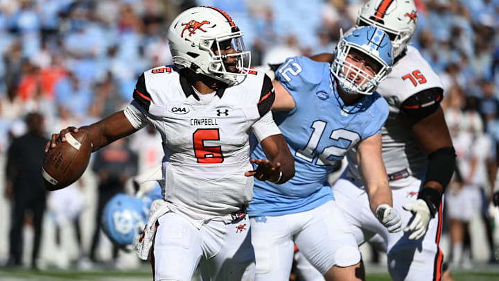 Nov 4, 2023; Chapel Hill, North Carolina, USA;  Campbell Fighting Camels quarterback Hajj-Malik Williams (6) looks to pass as North Carolina Tar Heels defensive lineman Beau Atkinson (12) pressures in the third quarter at Kenan Memorial Stadium. Mandatory Credit: Bob Donnan-Imagn Images