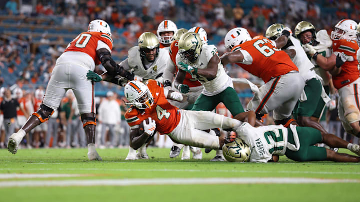 Sep 13, 2025; Miami Gardens, Florida, USA; Miami Hurricanes running back Mark Fletcher Jr. (4) reaches for extra yards against the South Florida Bulls in the fourth quarte at Hard Rock Stadium. Mandatory Credit: Nathan Ray Seebeck-Imagn Images