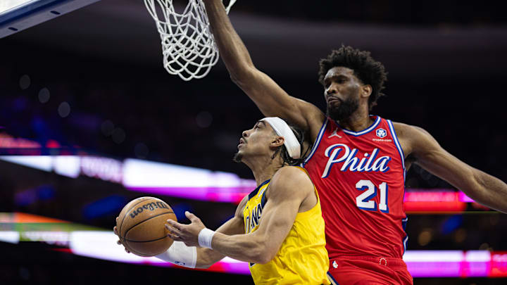 Dec 13, 2024; Philadelphia, Pennsylvania, USA; Indiana Pacers guard Andrew Nembhard (2) drives for a shot against Philadelphia 76ers center Joel Embiid (21) during the first quarter at Wells Fargo Center. Mandatory Credit: Bill Streicher-Imagn Images