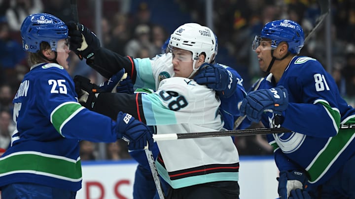 Apr 2, 2025; Vancouver, British Columbia, CAN;  Vancouver Canucks defenseman Elias Pettersson (25) fights Seattle Kraken forward Jani Nyma (38) during the third period at Rogers Arena. Mandatory Credit: Simon Fearn-Imagn Images