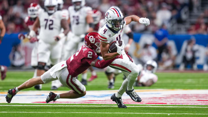 Dec 28, 2023; San Antonio, TX, USA; Oklahoma Sooners defensive back Billy Bowman Jr. (2) brings down Arizona Wildcats wide receiver Tetairoa McMillan (4) in the first half at Alamodome. Mandatory Credit: Daniel Dunn-USA TODAY Sports Dec 28, 2023; San Antonio, TX, USA; Oklahoma Sooners defensive back Billy Bowman Jr. (2) brings down Arizona Wildcats wide receiver Tetairoa McMillan (4) in the first half at Alamodome. Mandatory Credit: Daniel Dunn-USA TODAY Sports