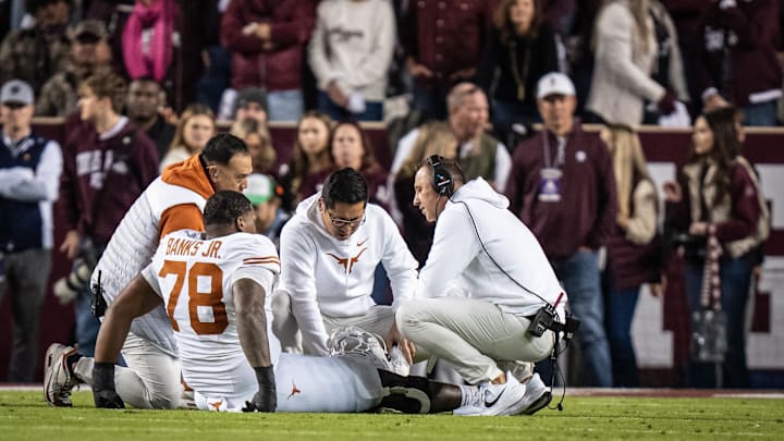 Nov 30, 2024; College Station, Texas, USA; Texas staff and Head Coach Steve Sarkisian attend to Texas Longhorns offensive lineman Kelvin Banks Jr. (78) after an injury in the first quarter of the Lone Star Showdown game against the Texas A&M Aggies at Kyle Field. Mandatory Credit: Sara Diggins/USA TODAY Network via Imagn Images Nov 30, 2024; College Station, Texas, USA; Texas staff and Head Coach Steve Sarkisian attend to Texas Longhorns offensive lineman Kelvin Banks Jr. (78) after an injury in the first quarter of the Lone Star Showdown game against the Texas A&M Aggies at Kyle Field. Mandatory Credit: Sara Diggins/USA TODAY Network via Imagn Images