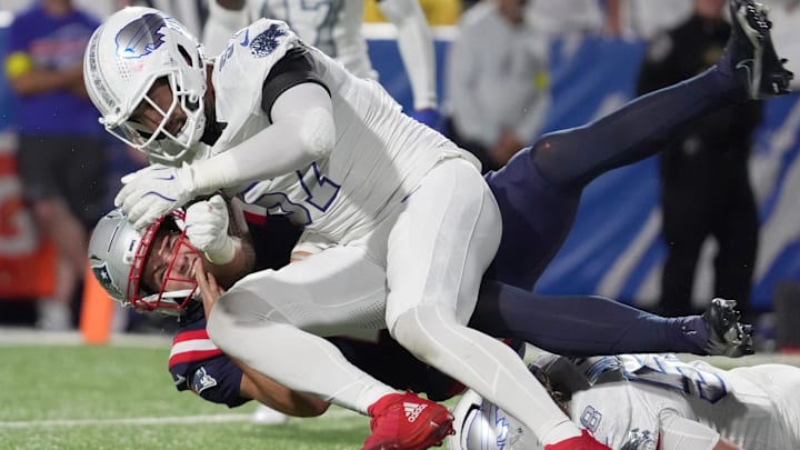 Buffalo Bills defensive end A.J. Epenesa tackles New England Patriots quarterback Drake Maye.