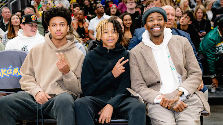 JJ Crawford, middle, takes in an NBA game with his dad, Jamal.
