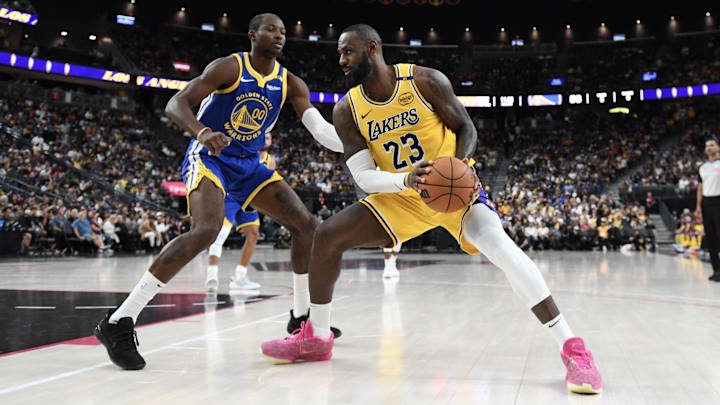 Oct 15, 2024; Las Vegas, Nevada, USA; Golden State Warriors forward Jonathan Kuminga (00) defends against Los Angeles Lakers forward LeBron James (23) during the third quarter of their preseason game at T-Mobile Arena. Mandatory Credit: Candice Ward-Imagn Images