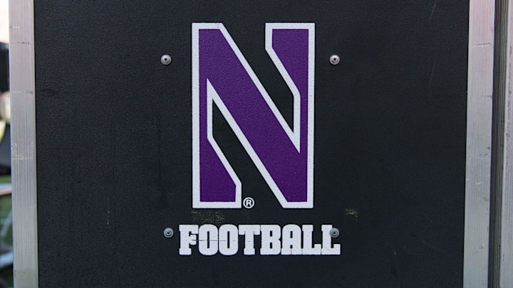 An equipment trailer bearing the Northwestern logo sits on the sidelines of Camp Randall Stadium during a 2017 football game.