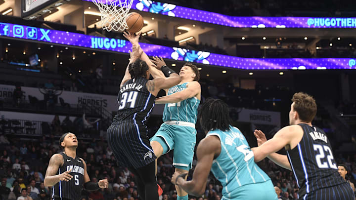 Mar 25, 2025; Charlotte, North Carolina, USA;  Charlotte Hornets forward Tidjane Salaun (31) drives in as he is defended by Orlando Magic center Wendell Carter Jr. (34) during the second half at the Spectrum Center. Mandatory Credit: Sam Sharpe-Imagn Images